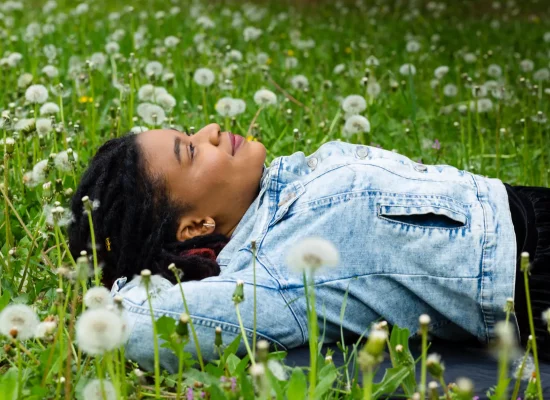 Woman lays down smiling, happy to be receiving help with her unplanned pregnancy